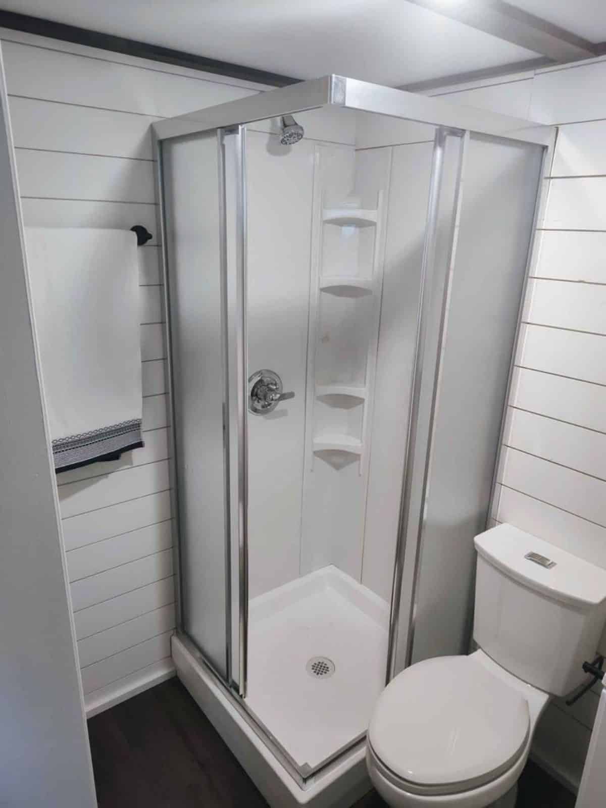 Separate shower area with glass door in bathroom of 38’ Tiny House