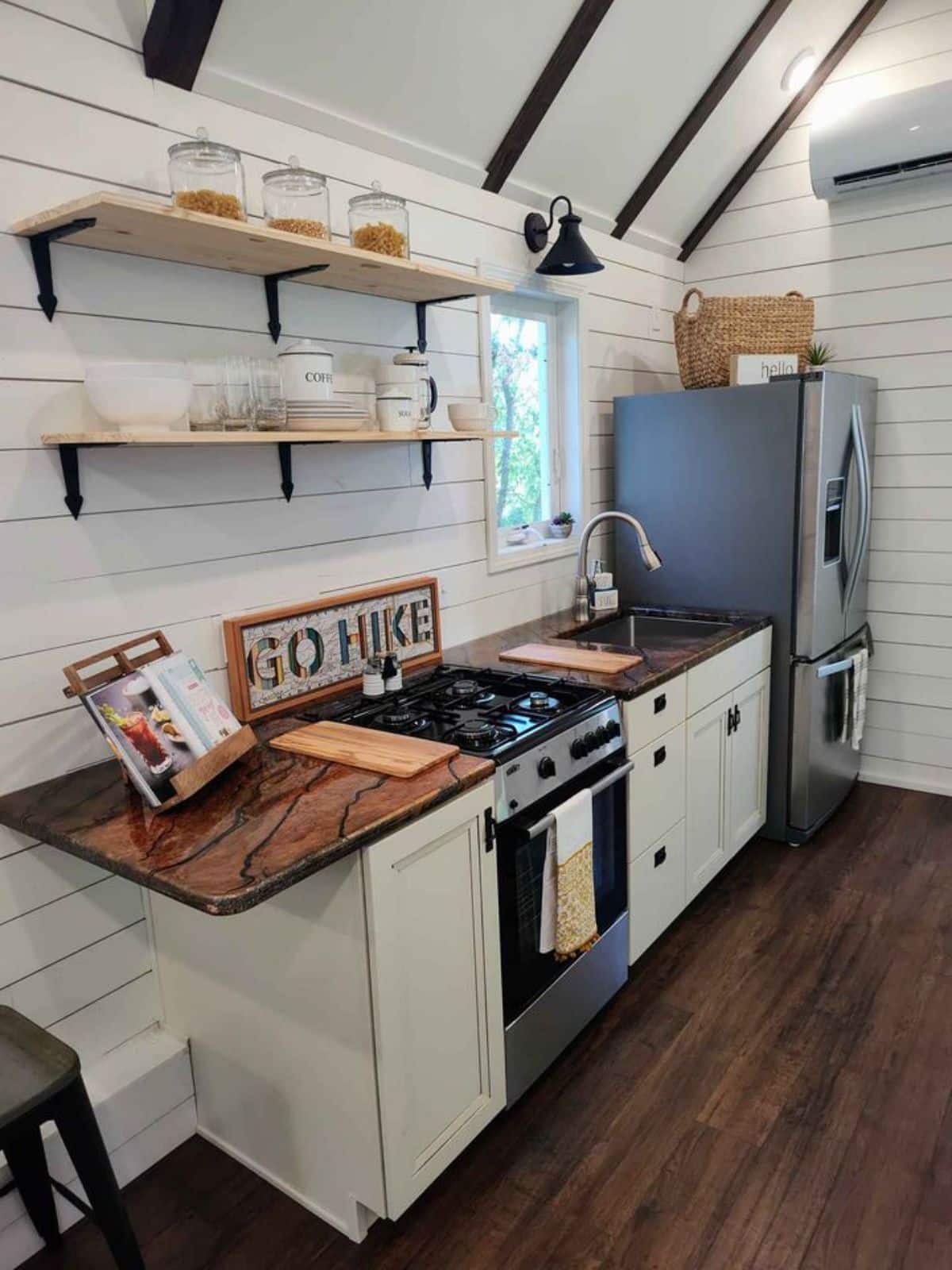 Well organized kitchen area of 38’ Tiny House has a burner and refregerator