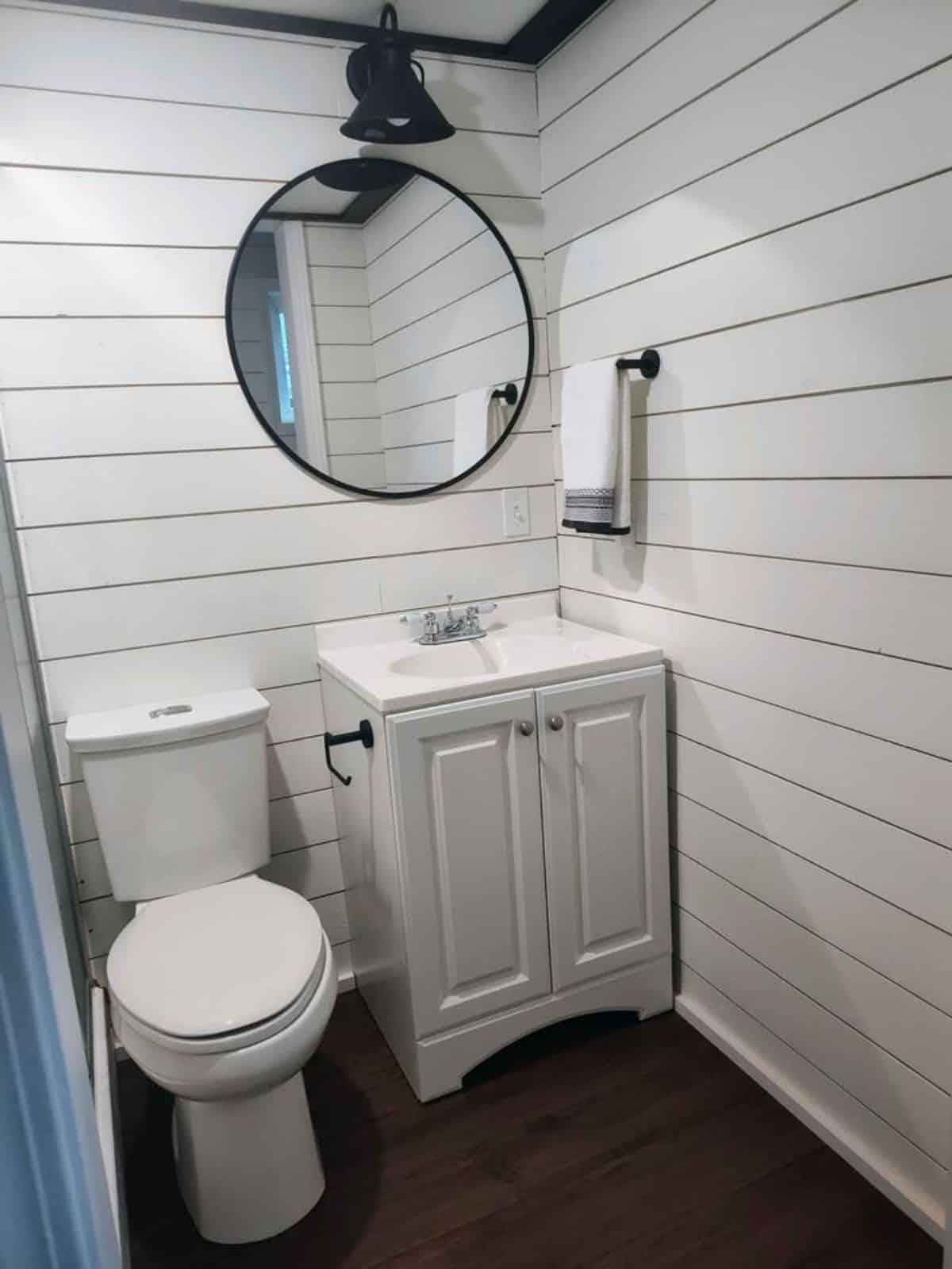 Sink with vanity & mirror and standard toilet in bathroom of 38’ Tiny House