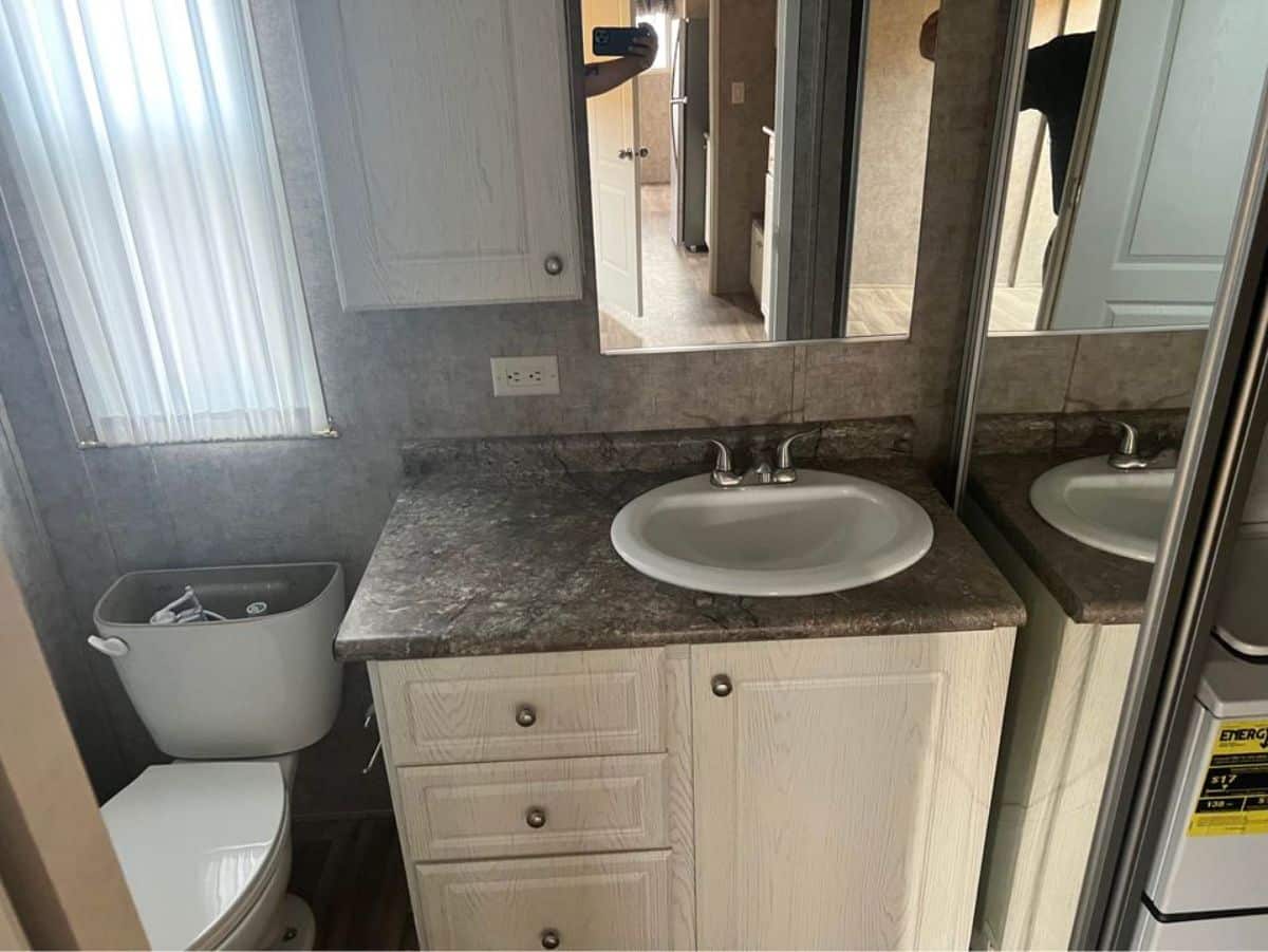 Sink with vanity & mirror in bathroom of 399 sf Tiny House