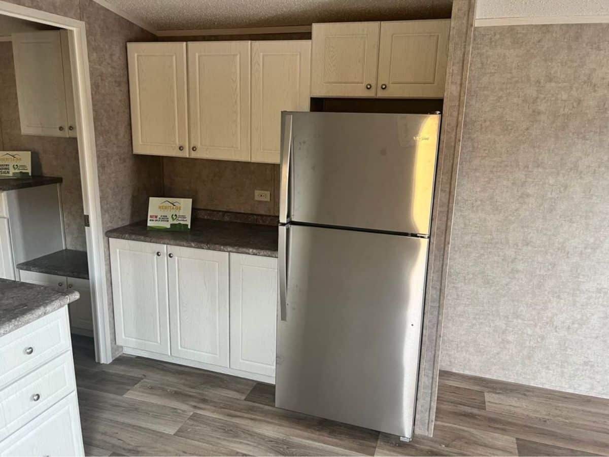 Storage cabinets and refrigerator on the right side of the kitchen of 399 sf Tiny House