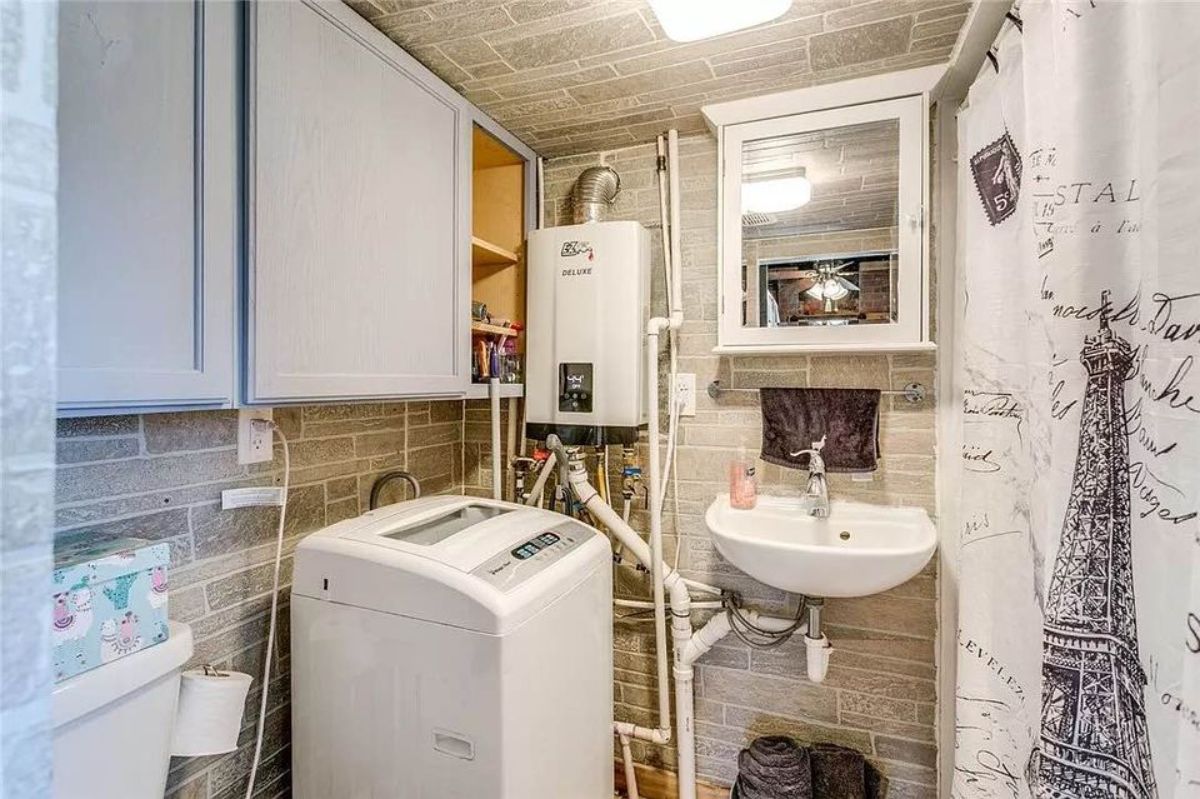 Bathroom of Adorable Tiny House with Land has a washing machine