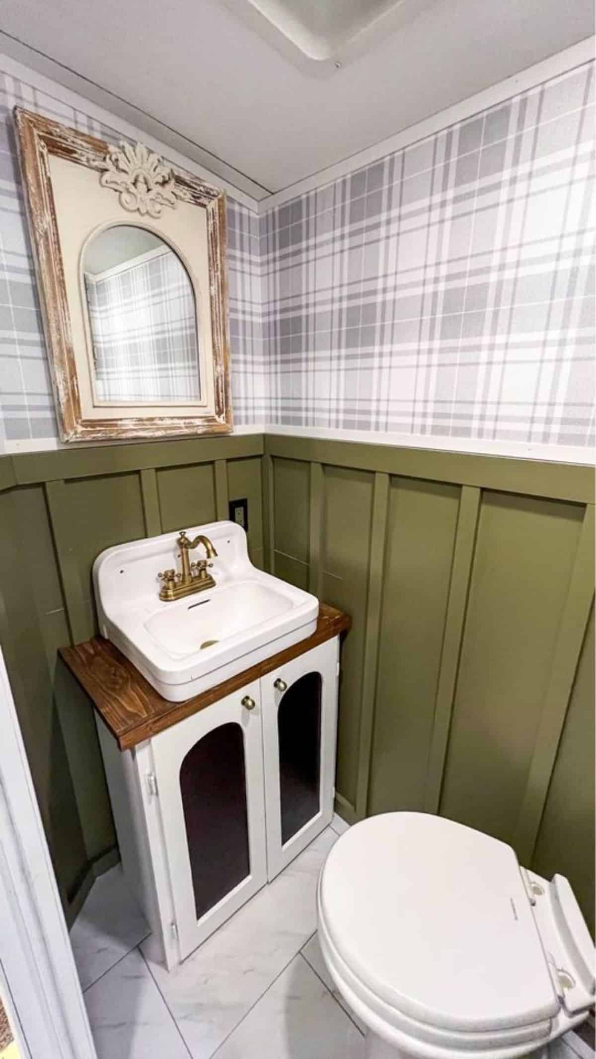 Sink with vanity & mirror and standard toilet in bathroom of 40' Tiny House