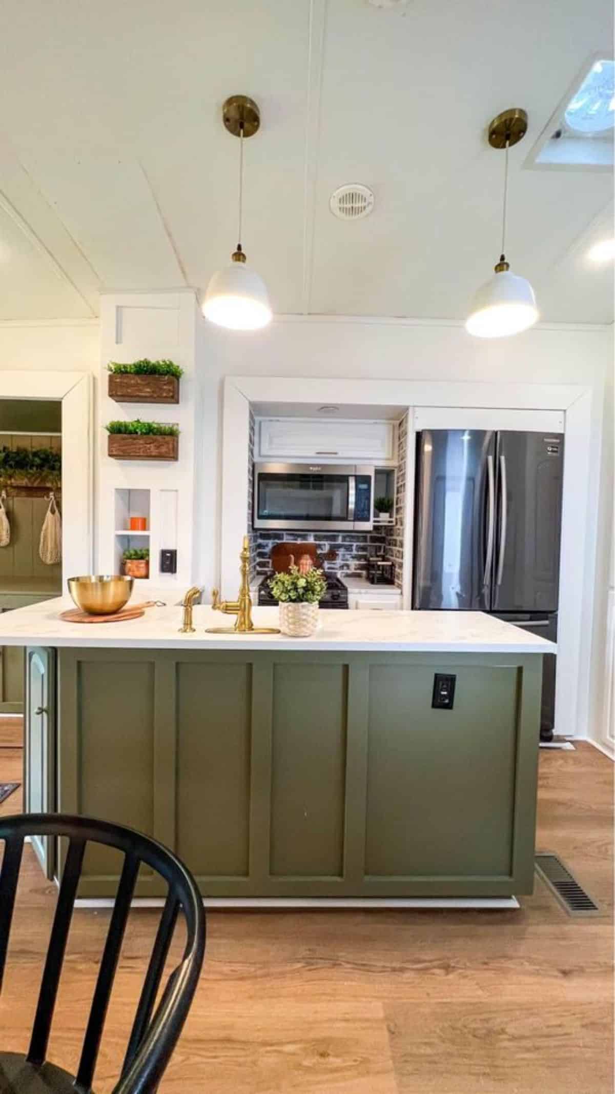 Well organized kitchen of 40' Tiny House has a double door refrigerator, an oven and brand new countertop