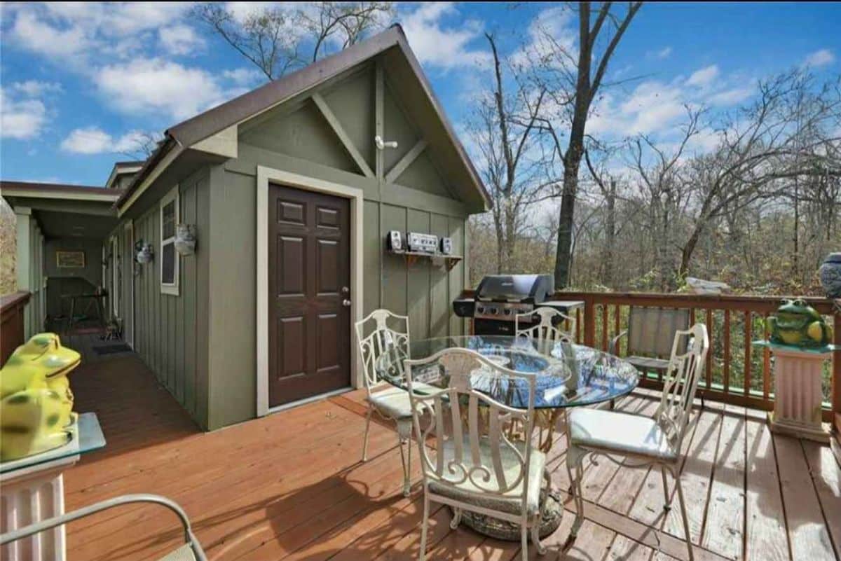 Small porch outside the door of Spacious 3 Bedroom Tiny House has a small table and chair combo
