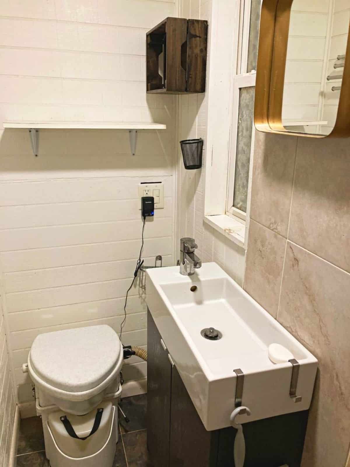 Sink with mirror and standard toilet in bathroom