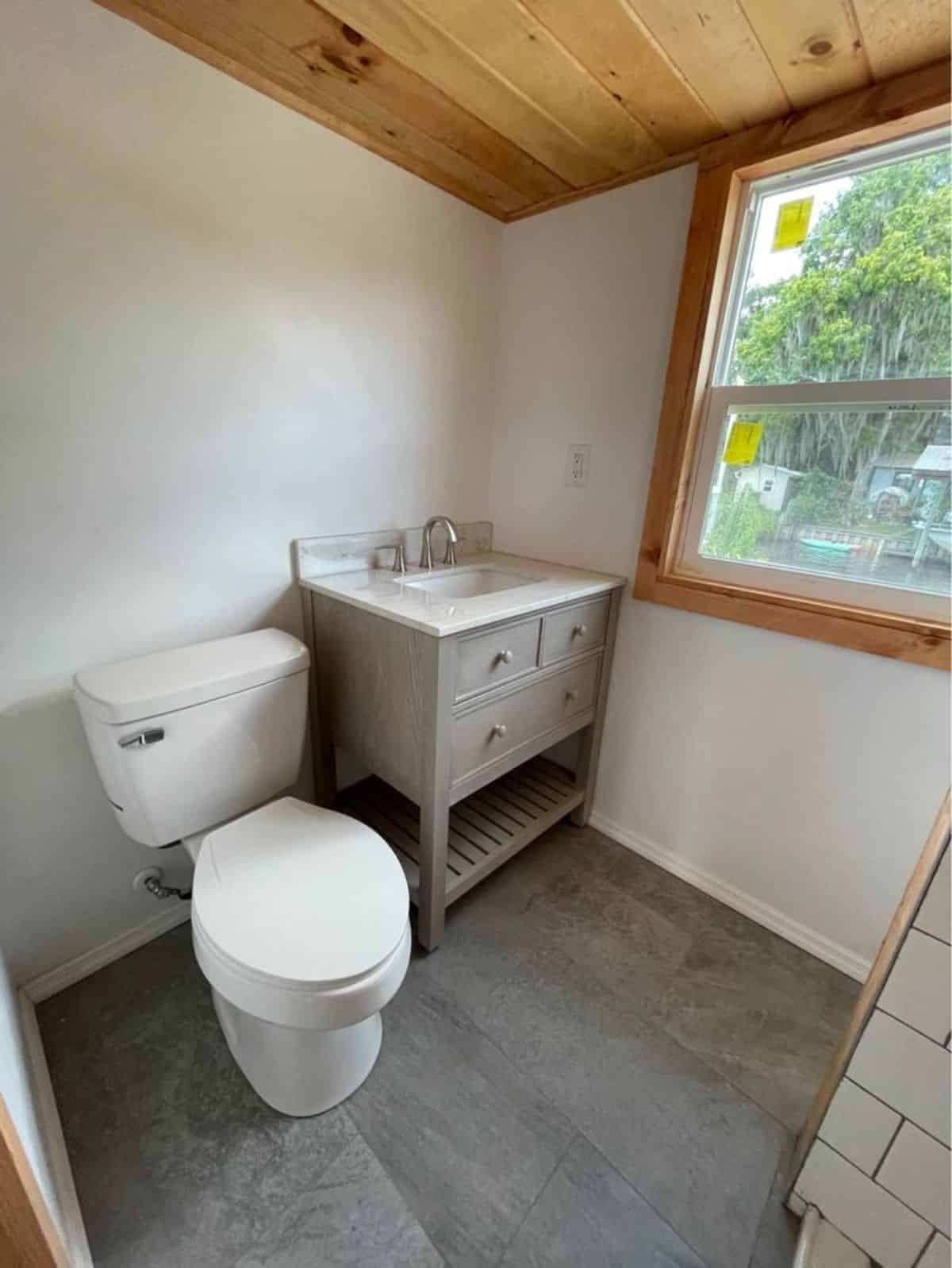 Sink with vanity and standard toilet in bathroom of 20' Towable Tiny Home