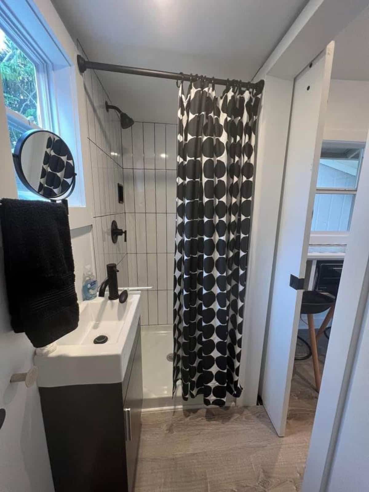 White marble shower area in bathroom of 20' Trendy Tiny Home