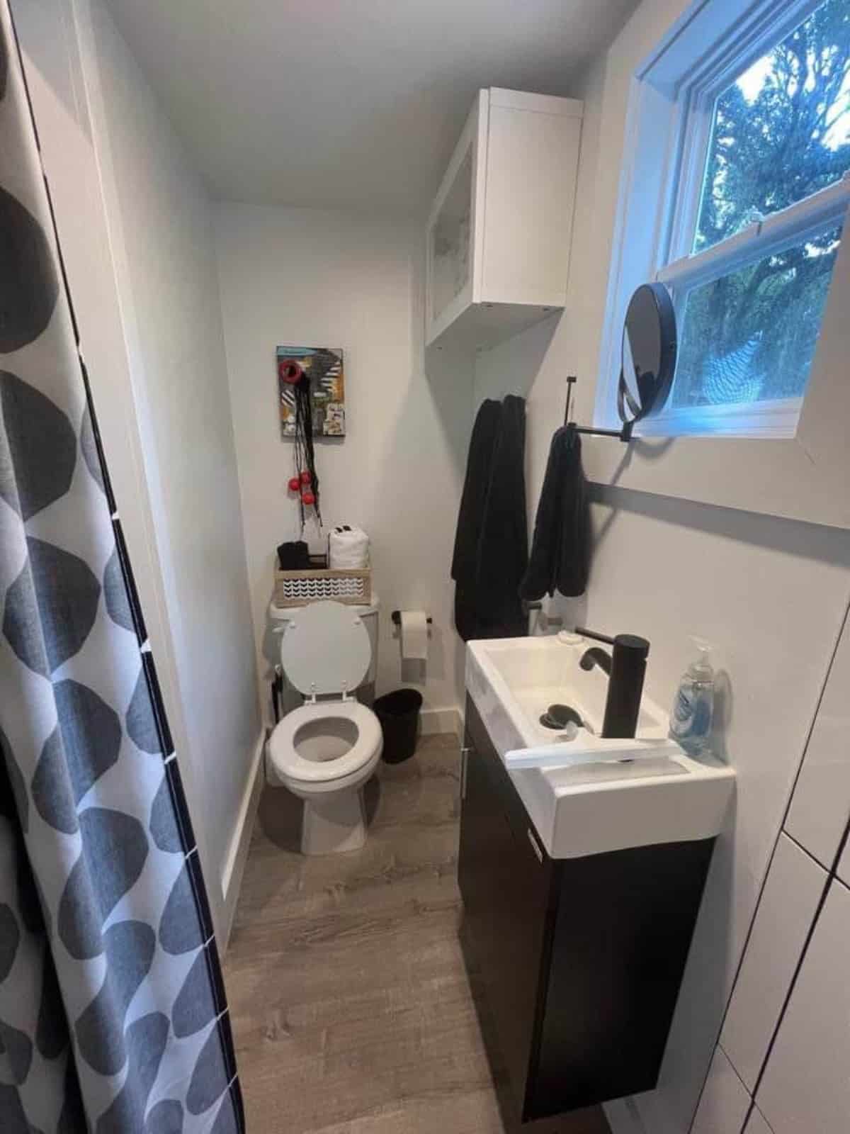 Sink with vanity & mirror with standard toilet in bathroom