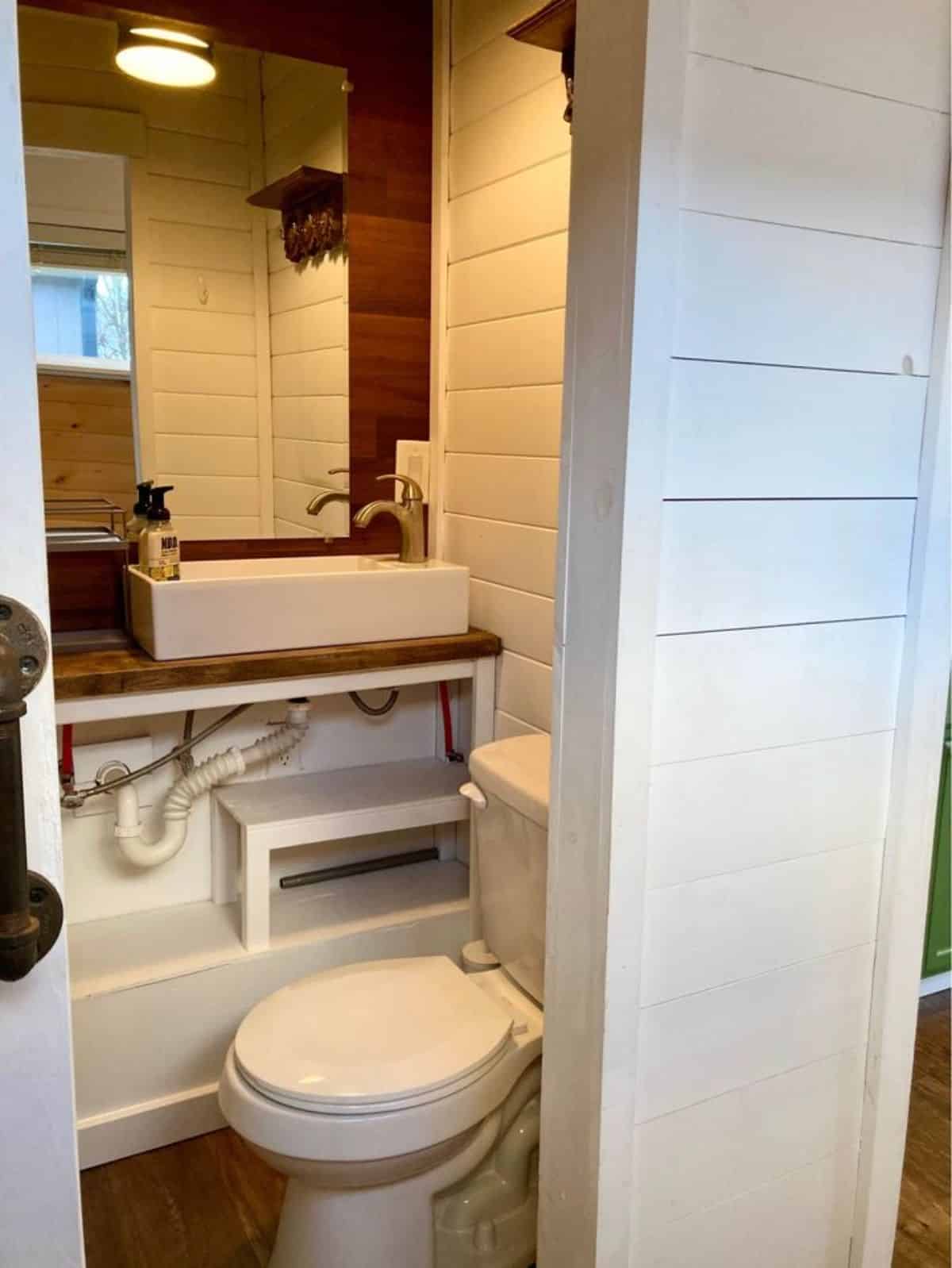 Sink with vanity & mirror and standard toilet in bathroom of 25' Beautiful Tiny Home