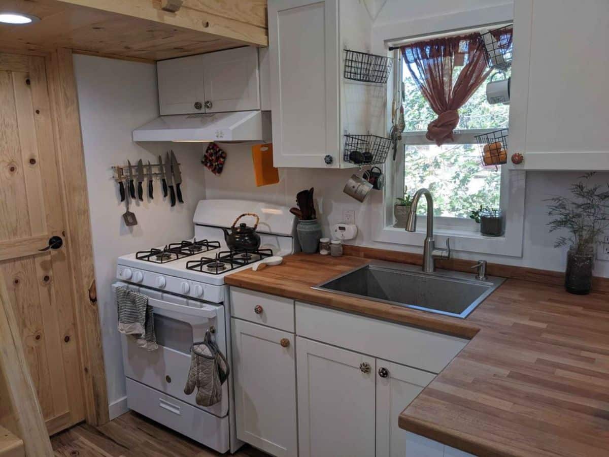Kitchen area of 30' Custom Built Tiny Home on Wheels is L shaped with all the necessary equipment's