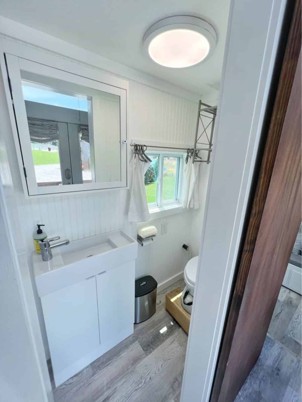 Sink with vanity and mirror and standard toilet in bathroom