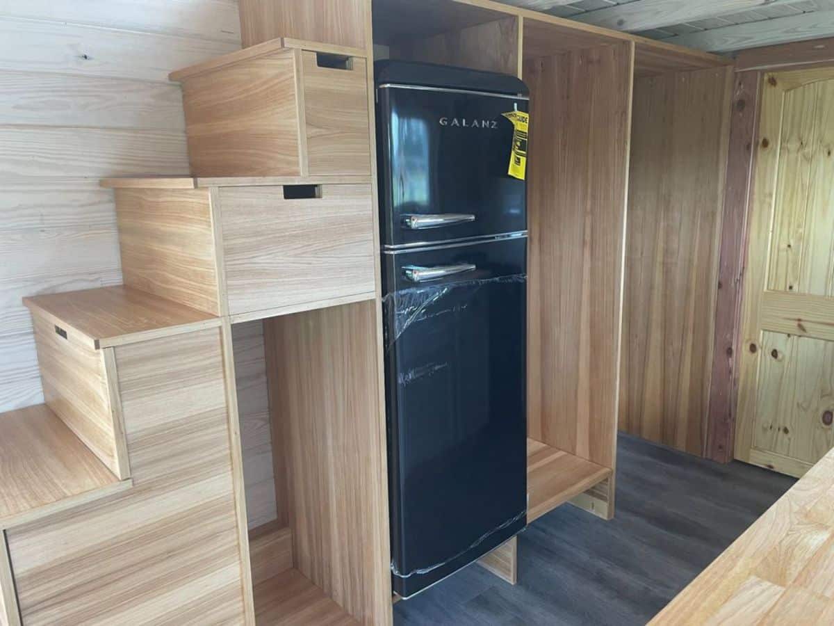 Refrigerator and storage under the stairs of 326 sf Spacious Tiny House