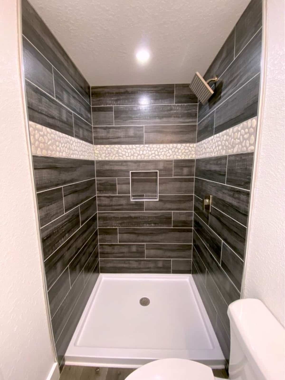 Classy shower area in bathroom of 40’ Shipping Container Tiny Home