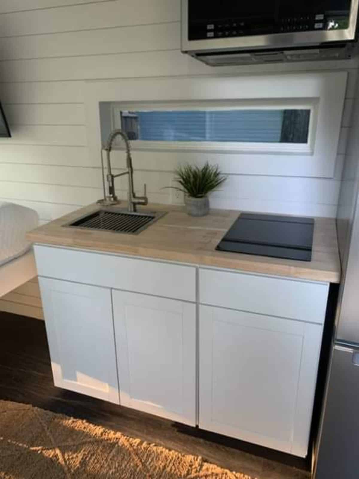 Small but neat kitchen area of Container Tiny House with double door refrigerator