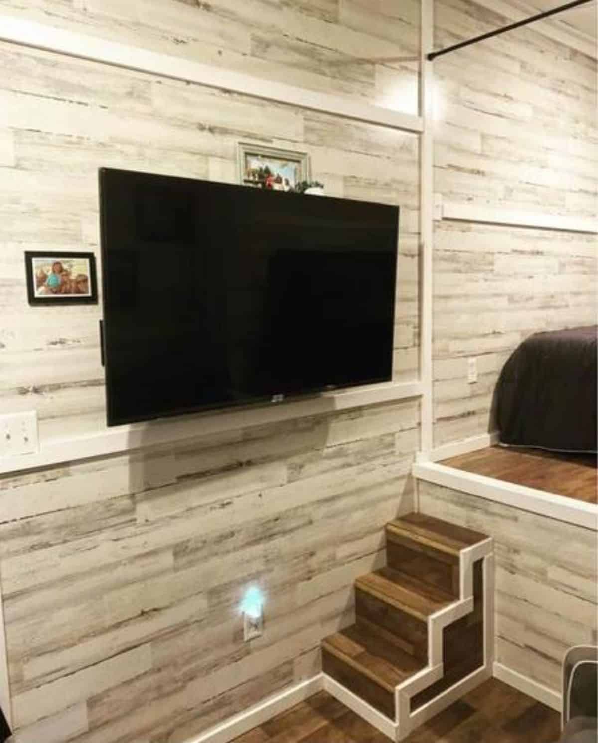 Wall mounted television set opposite to chair in living area