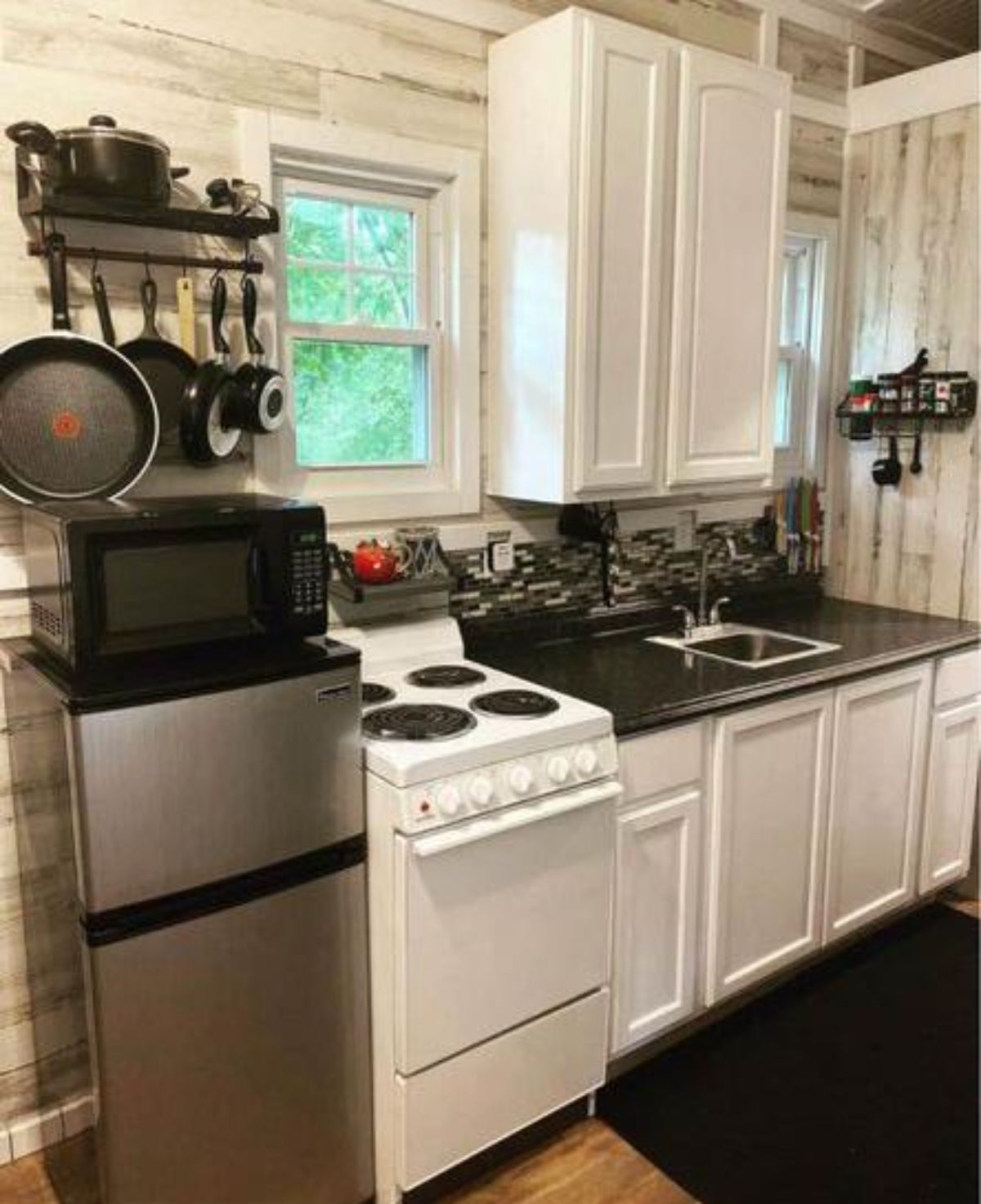 Kitchen area is equipped with propane gas burner, marble counter top, sink, refrigerator and microwave oven