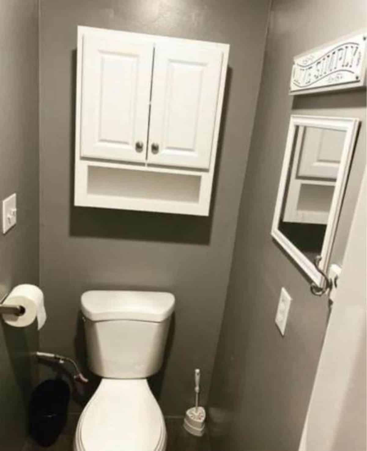 Standard toilet and storage in bathroom