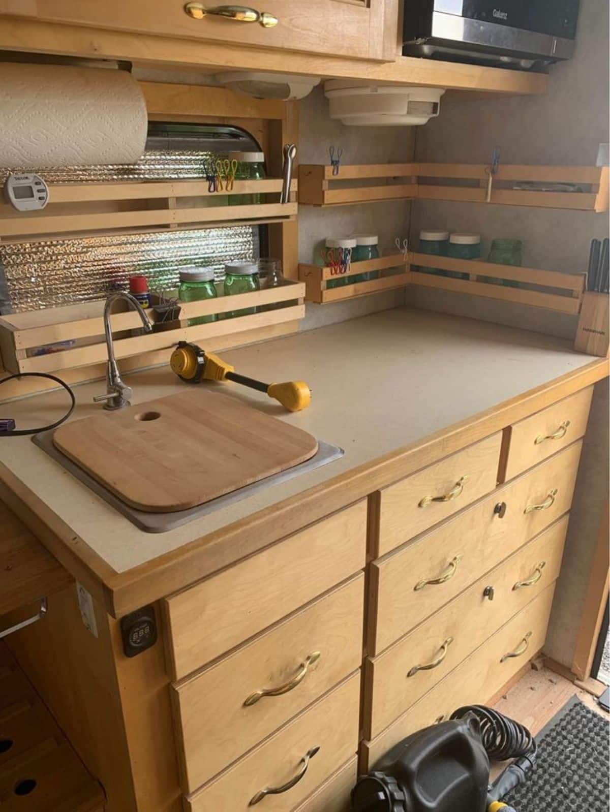 Kitchen area of Super Tiny Home on wheels has a lot of storage spaces