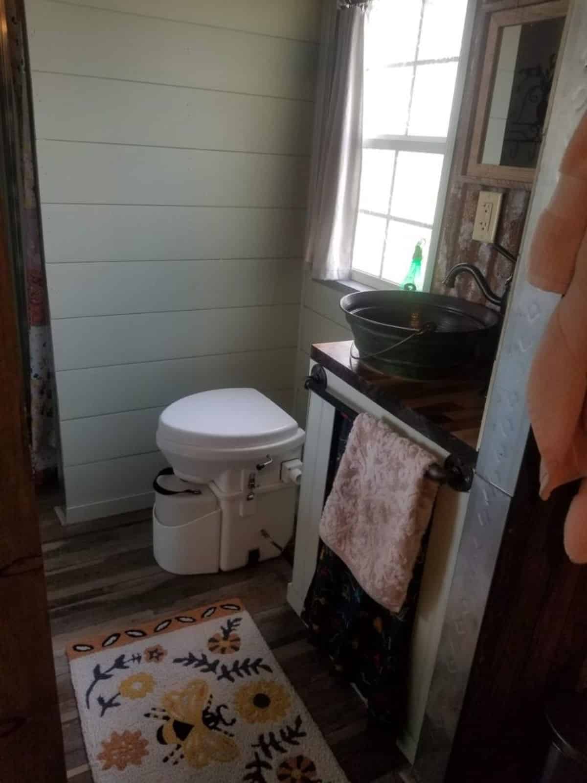 Standard toilet, sink with vanity in bathroom