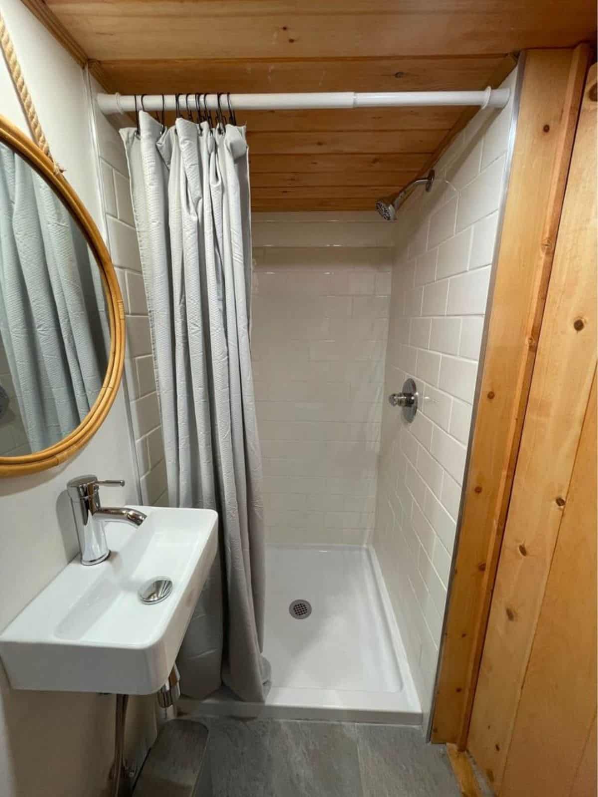 Sink with mirror and separate shower area in bathroom
