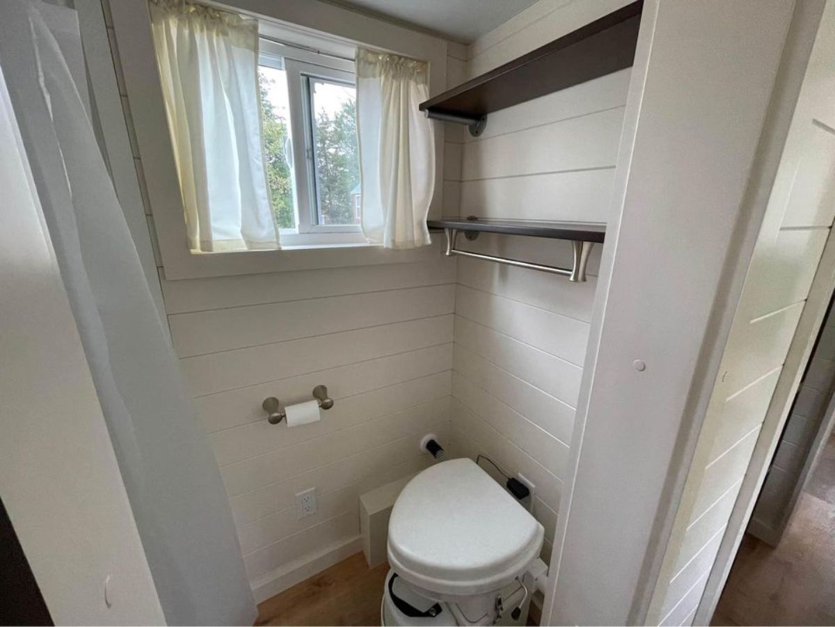 Bathroom is equipped with composting toilet and separate fiberglass shower area