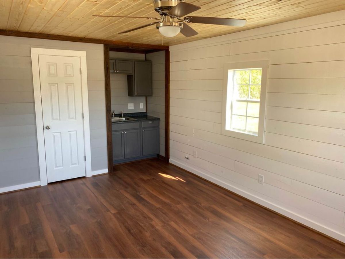 White walls sna wooden flooring of Small kitchen area of 24' Cabin Tiny House