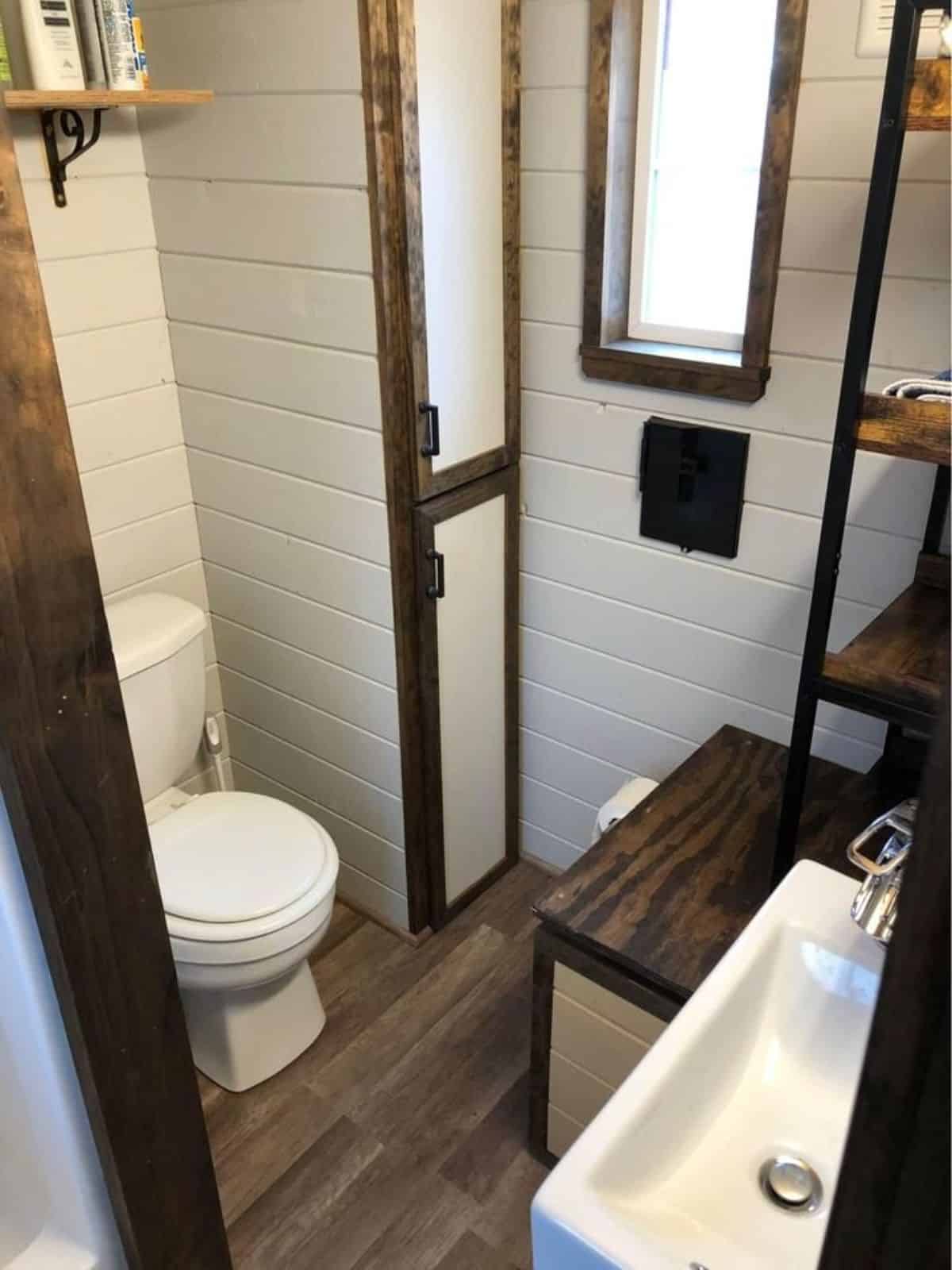 Standard toilet, sink with mirror in bathroom