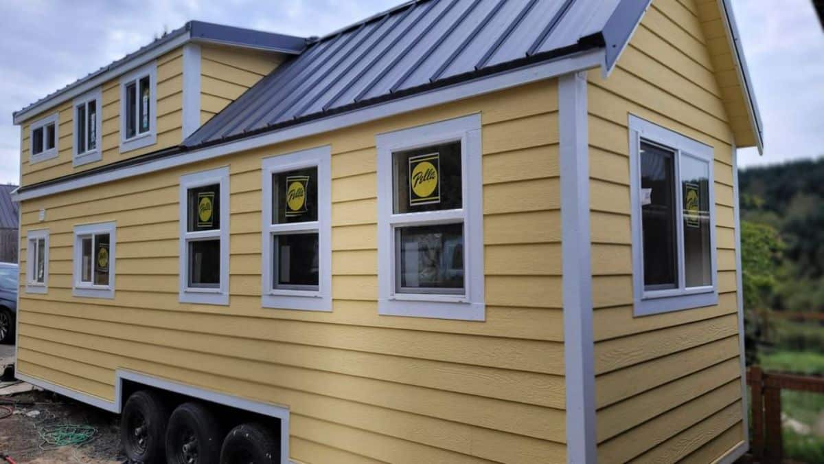 Bright yellow exterior of 28' Tiny House on Wheels makes it more bright with huge windows