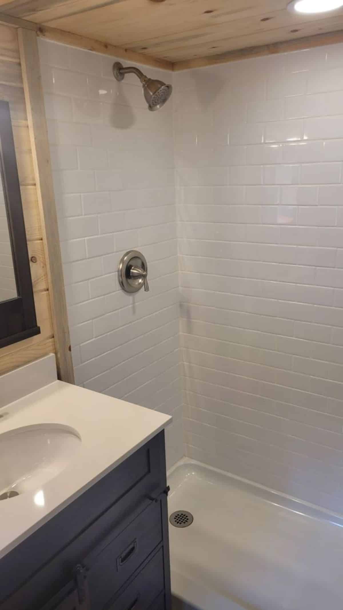 Separate shower area, sink with vanity in bathroom of 28’ tiny house on wheels