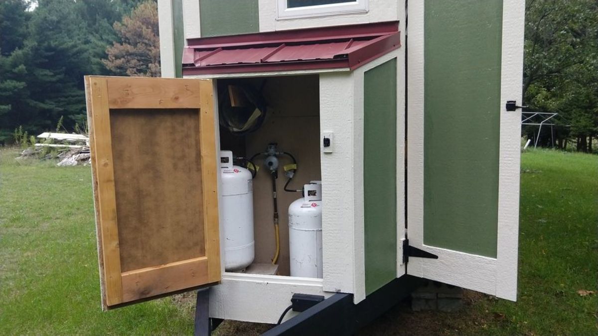 Water tank installed outside of tiny house with rooftop deck