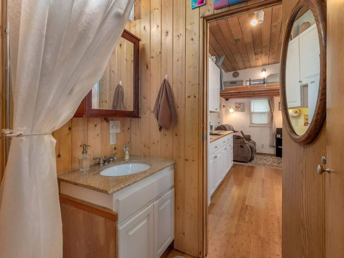 Bathroom of 29' Custom Tiny House has a sink with vanity and mirror