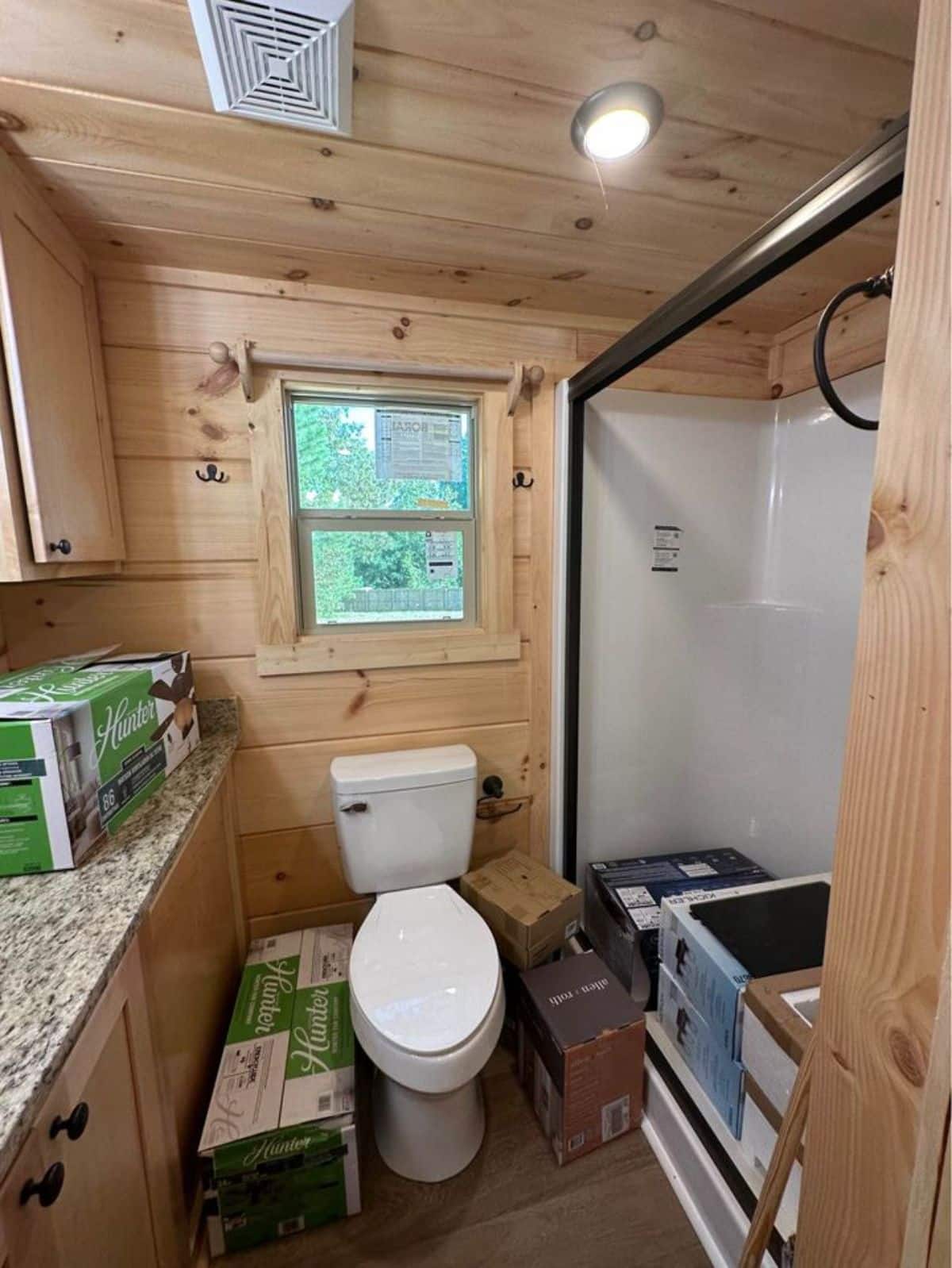Bathroom of 399-Square Footed Luxury Tiny House has a standard toilet, sink with vanity & mirror  with seperate shower area