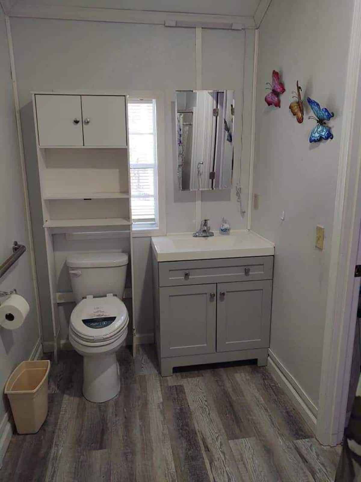 Bathroom of 40’ Tiny House has a standard toilet, sink with vanity & mirror and separate shower area