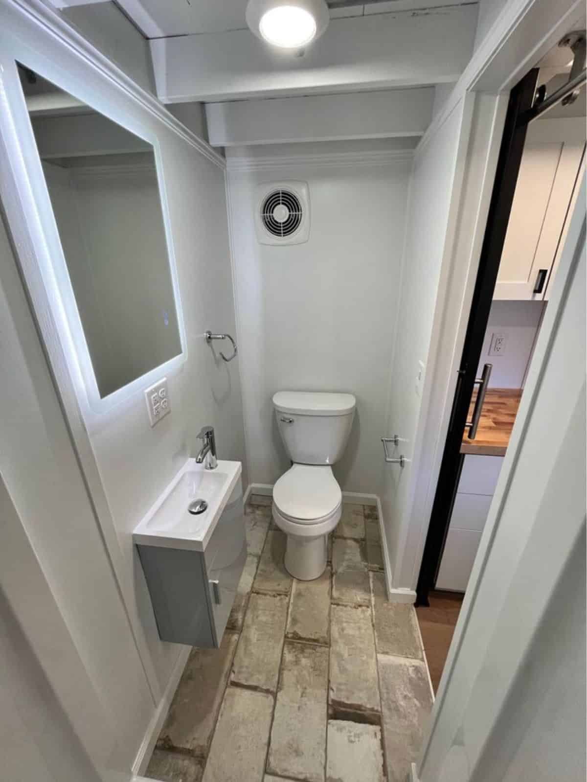 Standard toilet with small sink and vanity