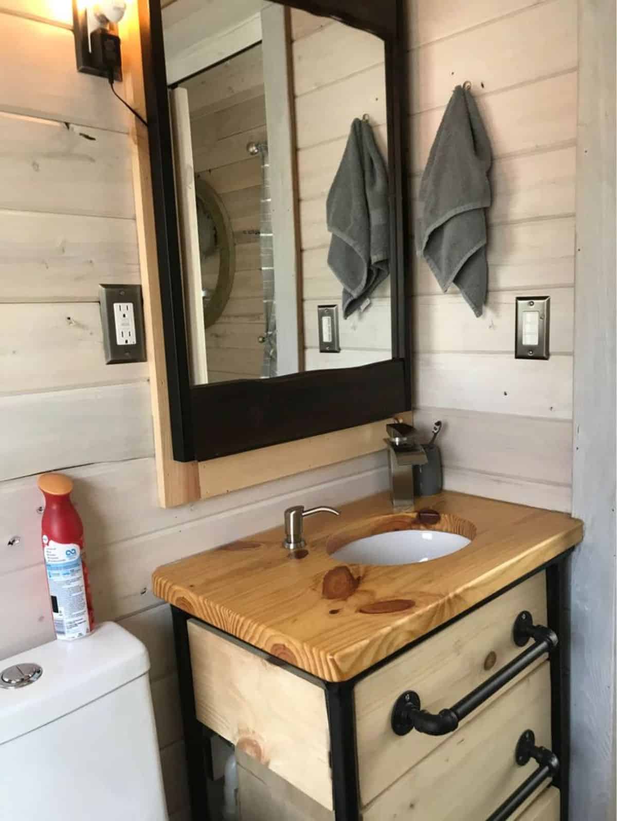 Sink with vanity and mirror in bathroom of Fully Equipped Tiny House