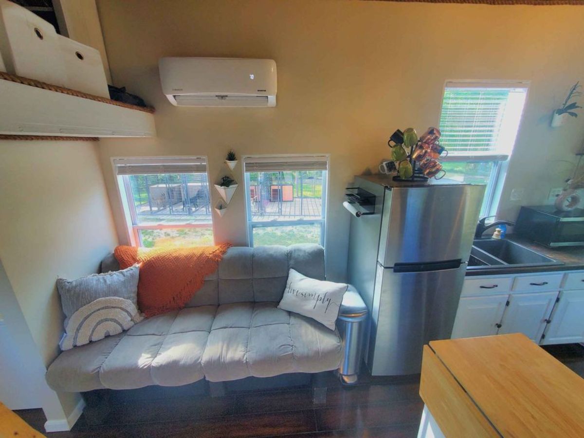 Comfortable couch with air condition unit in living area of Move-In Ready Tiny Home