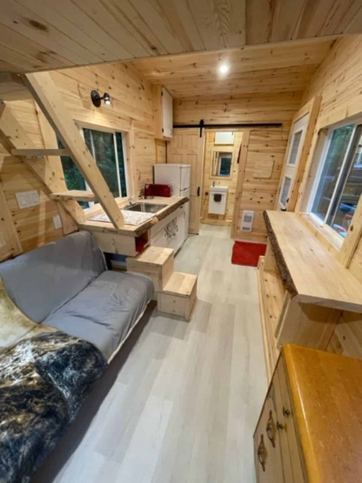 Living area of This Elegant Tiny Home has a couch and entertainment unit