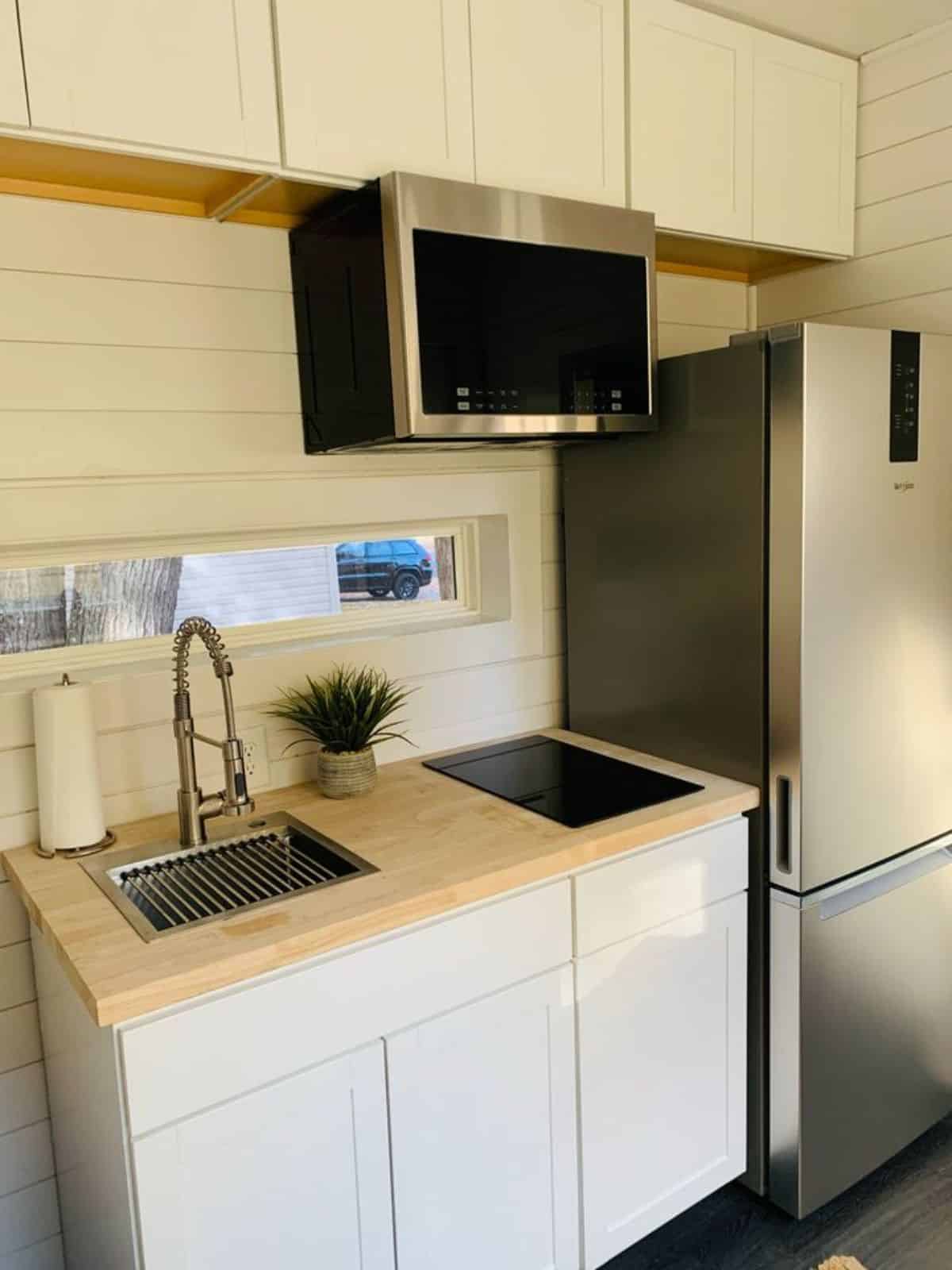 Compact but stylish kitchen area with lots of storage cabinets at 20'  Shipping Container Tiny House