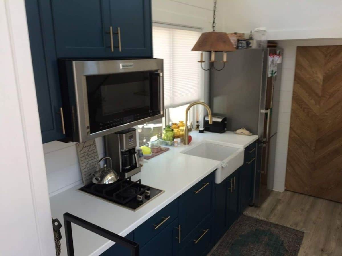 Stylish blue themed kitchen area of 26' Tiny Mobile Home