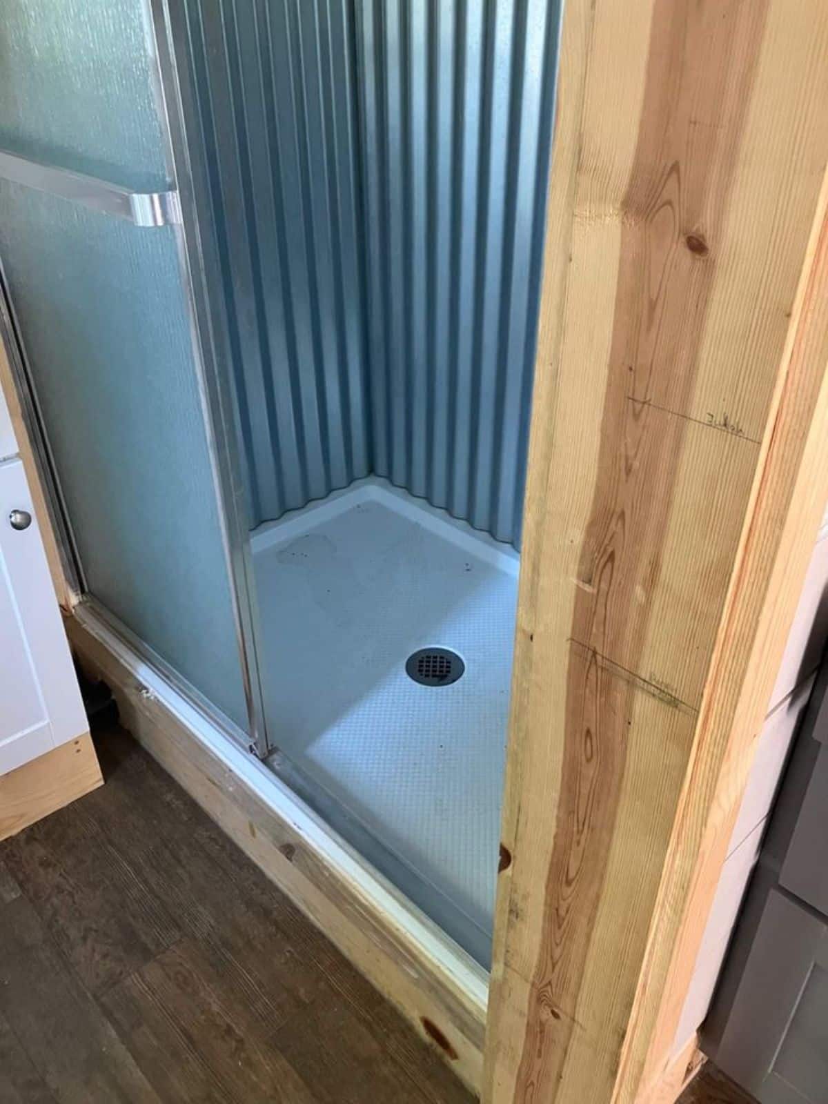 Bathroom of 30' Tiny House on Wheels has a separate shower area, toilte and small sink