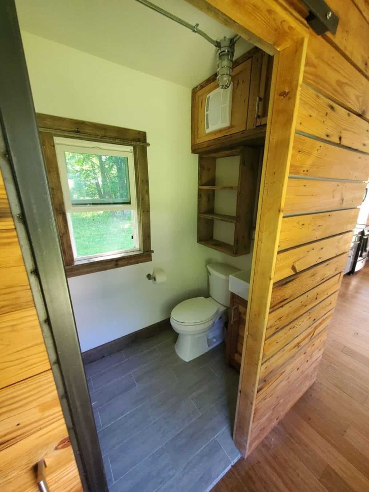 Standard toilet and sink with vanity in bathroom of 40' Luxury Shipping Container Tiny Home