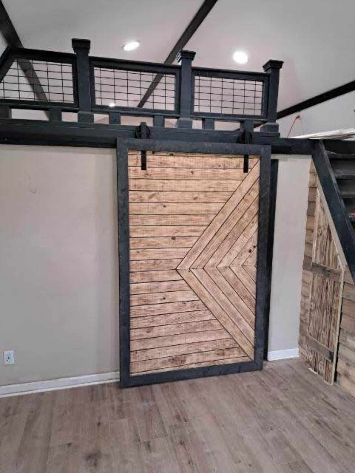 Sliding door towards the bathroom and besides stairs towards the loft bedroom of Aesthetic Tiny Home