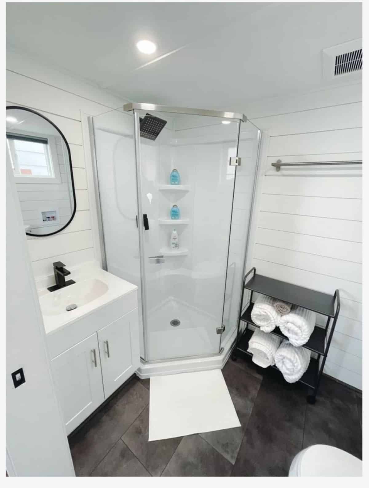Shower cubical , sink with vanity and mirror in bathroom