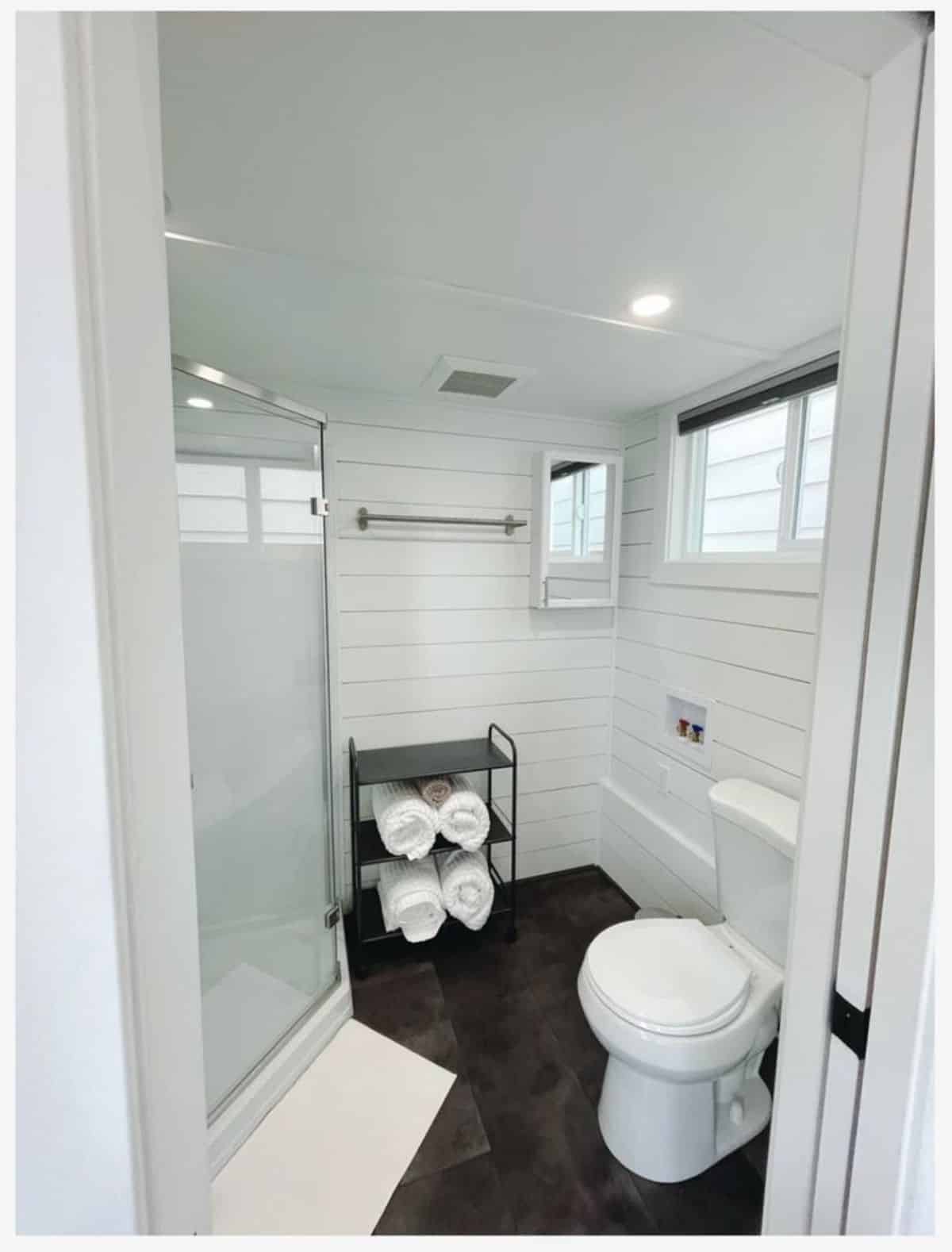 Standard toilet and Rack for towels and other toiletries in bathroom of Tiny Home with Financing