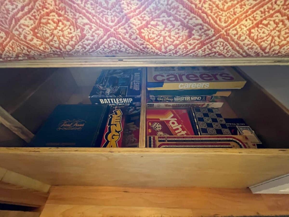 open drawer under seat filled with games