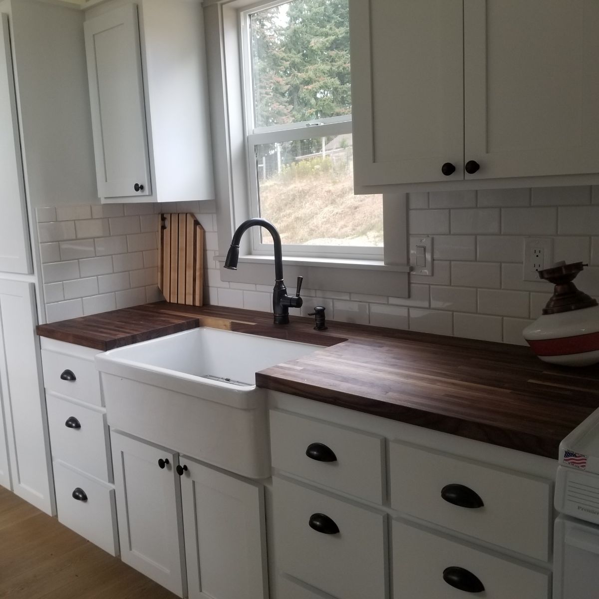 white cabinets under butcher block counter in tiny home kitchen