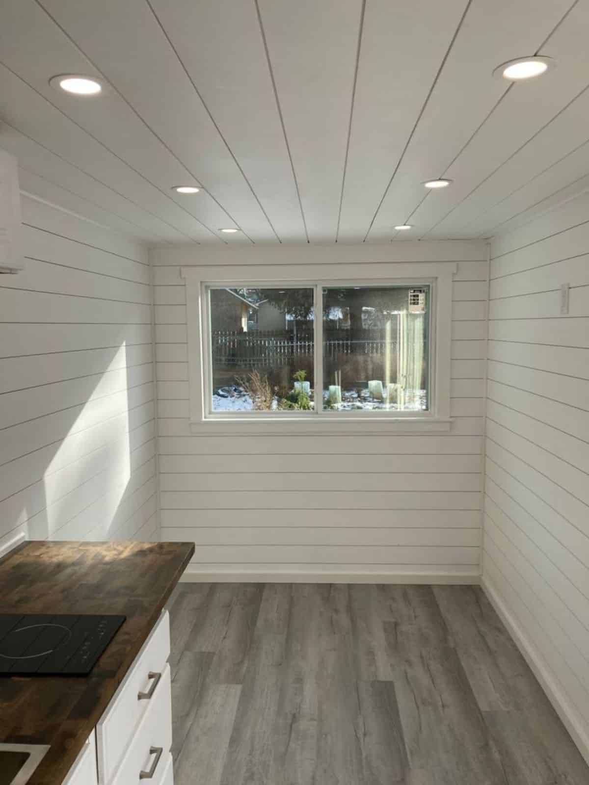 Living cum sleeping area of 20' Small Container Home has white walls and vinyl flooring