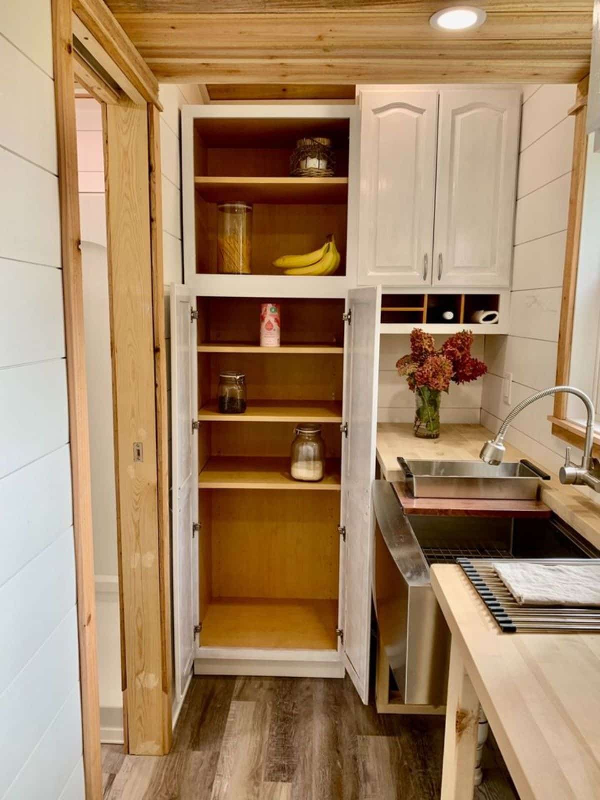 Storage cabinets in kitchen area of 20’ tiny home