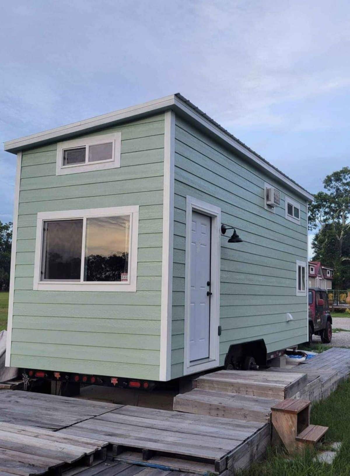 Green colored exterior and main entrance view of 20’ tiny house with two lofts